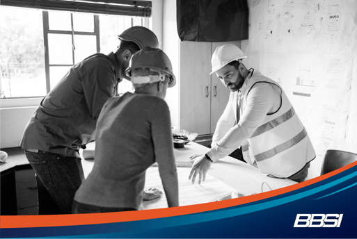 A group of construction workers at a table looking over plans.