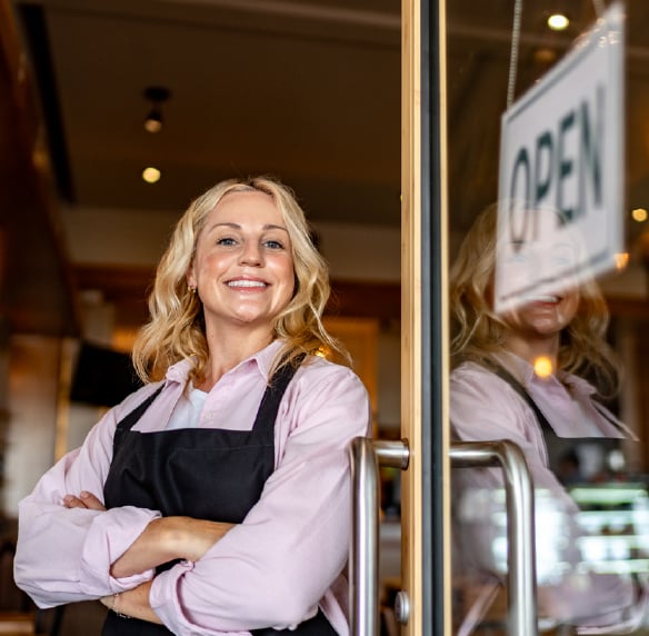 Restaurant franchise owner standing at the entrance of her business.