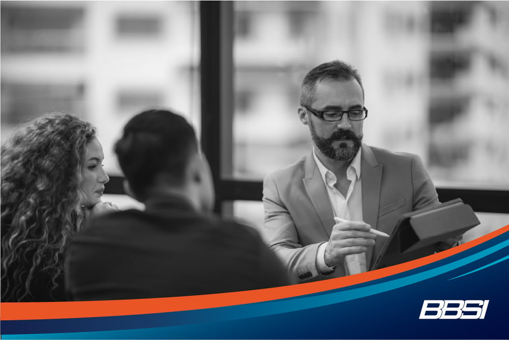 business owner looking at tablet with his team