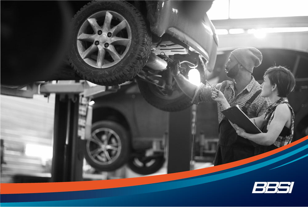 Two mechanics working on a car