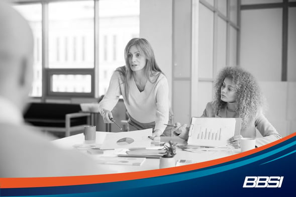 Businesswoman presenting reports and charts in a business forecasting meeting with a colleague.