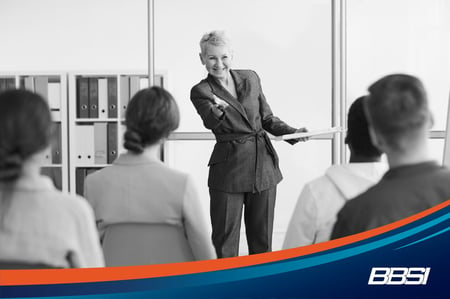 Businesswoman addresses room of people in an office