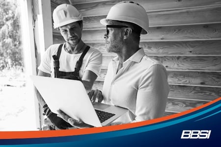 Construction workers looking at laptop