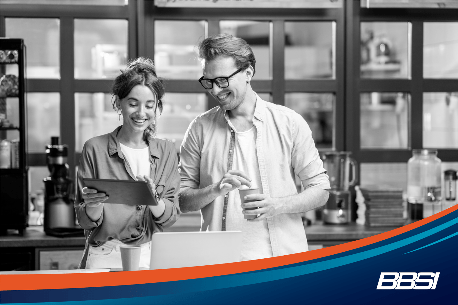 A man and a woman looking at a tablet smiling in a kitchen