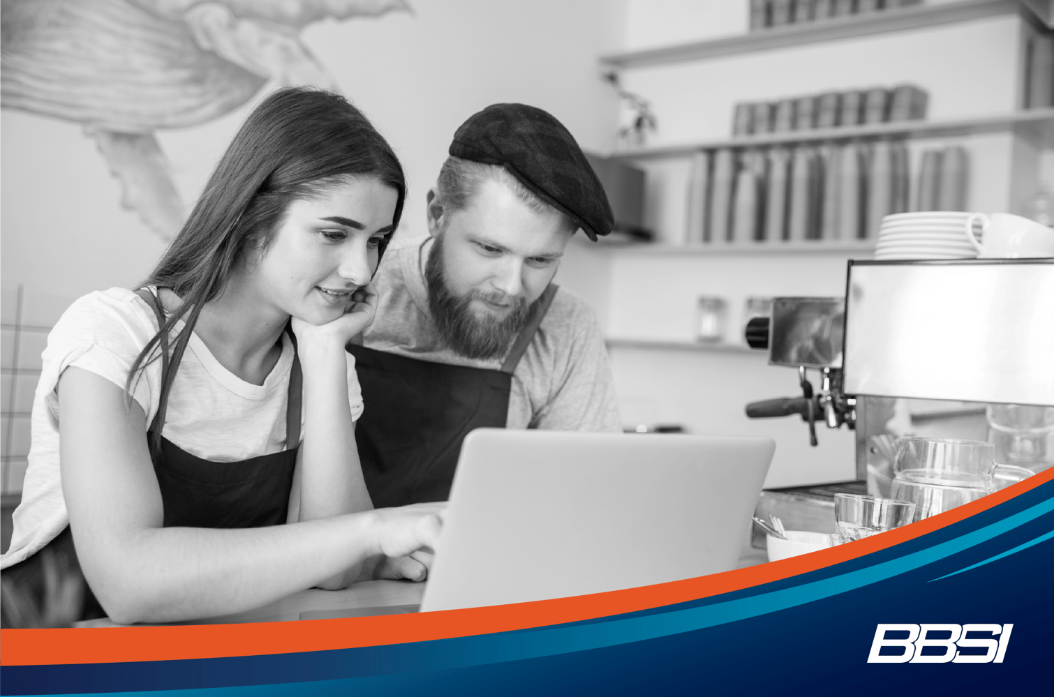 A man and woman are intently looking at a laptop, learning about the benefits of a good franchisee / franchise relationship