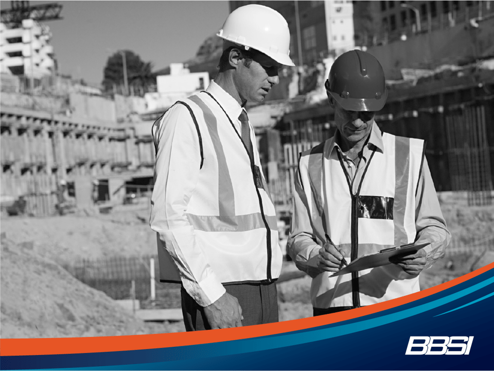 Two male construction workers look at an incident response plan after an incident occurs.