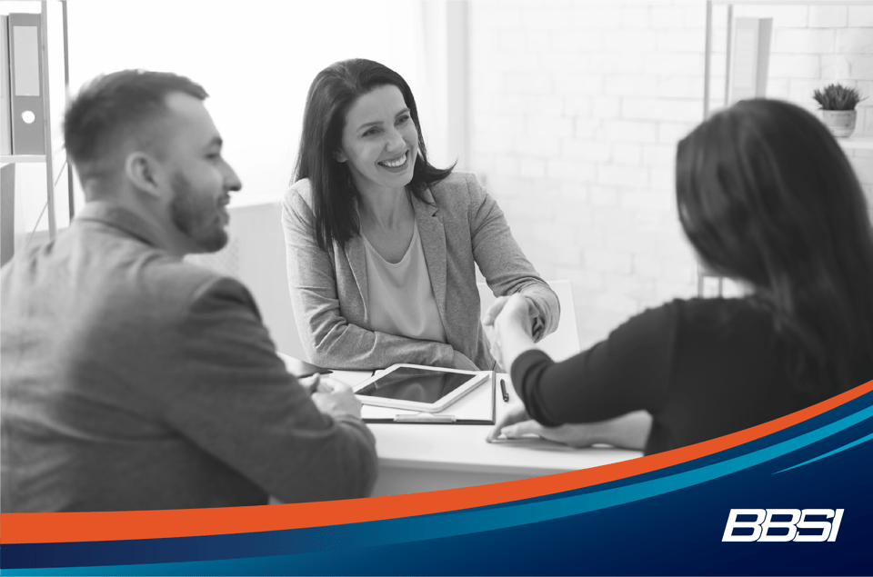 Woman shaking hands with an insurance broker at a meeting