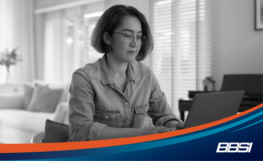 Woman sits at her desk looking at a computer while working on new strategies for her small business 