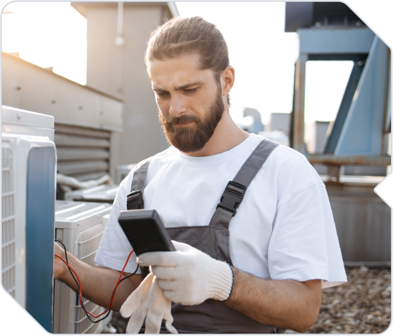 An HVAC business employee checking on an air conditioning unit.