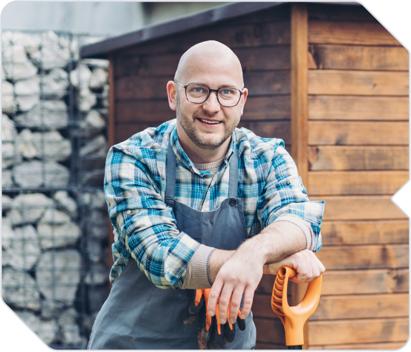 A landscaping worker smiling while working on the job.