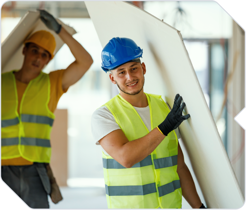 Restoration company workers carrying materials on a jobsite.