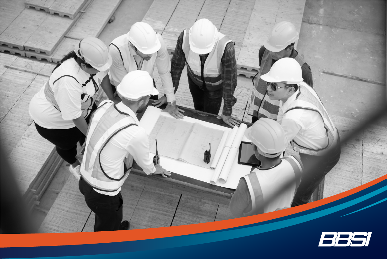 7 construction workers gather around a table to discuss the importance of behavioral safety awareness