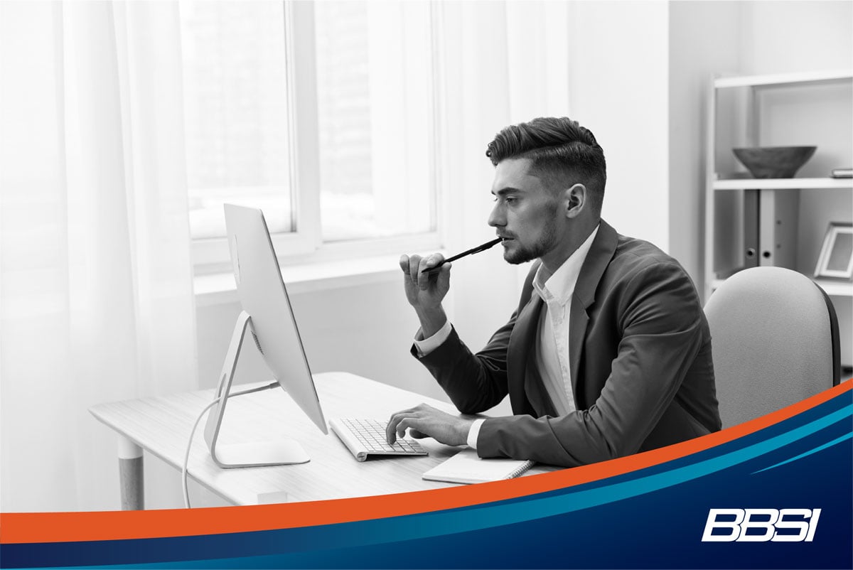 A young man in a blue suit researching automated payroll options