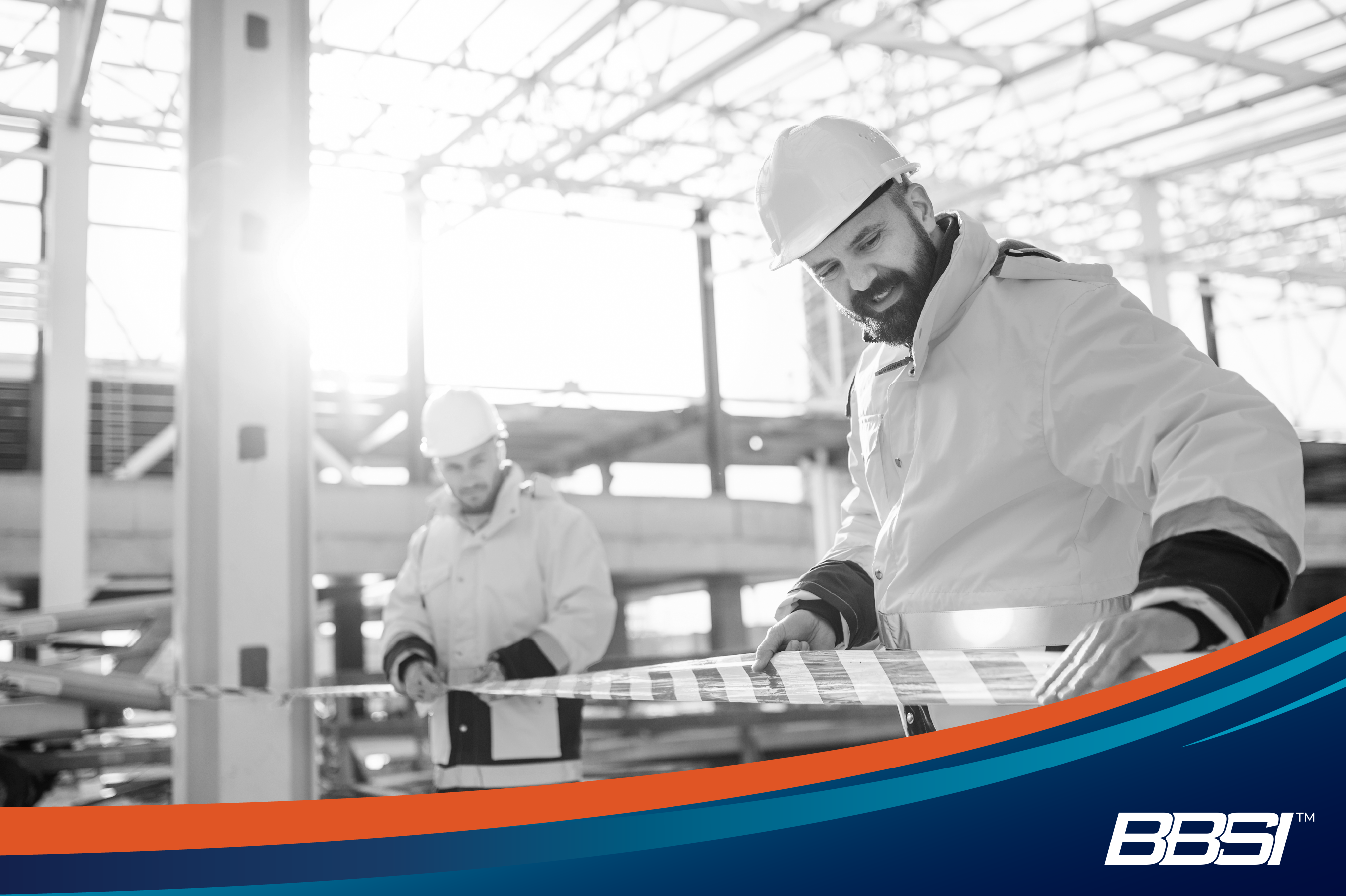 Workers at a construction site putting up safety tape