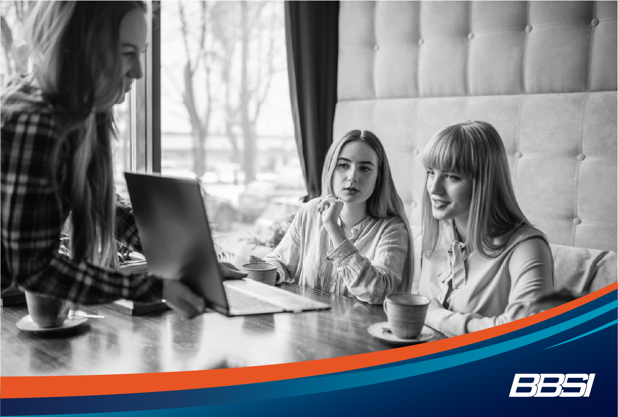 three women work on a marketing strategy for their small business in a coffee shop 