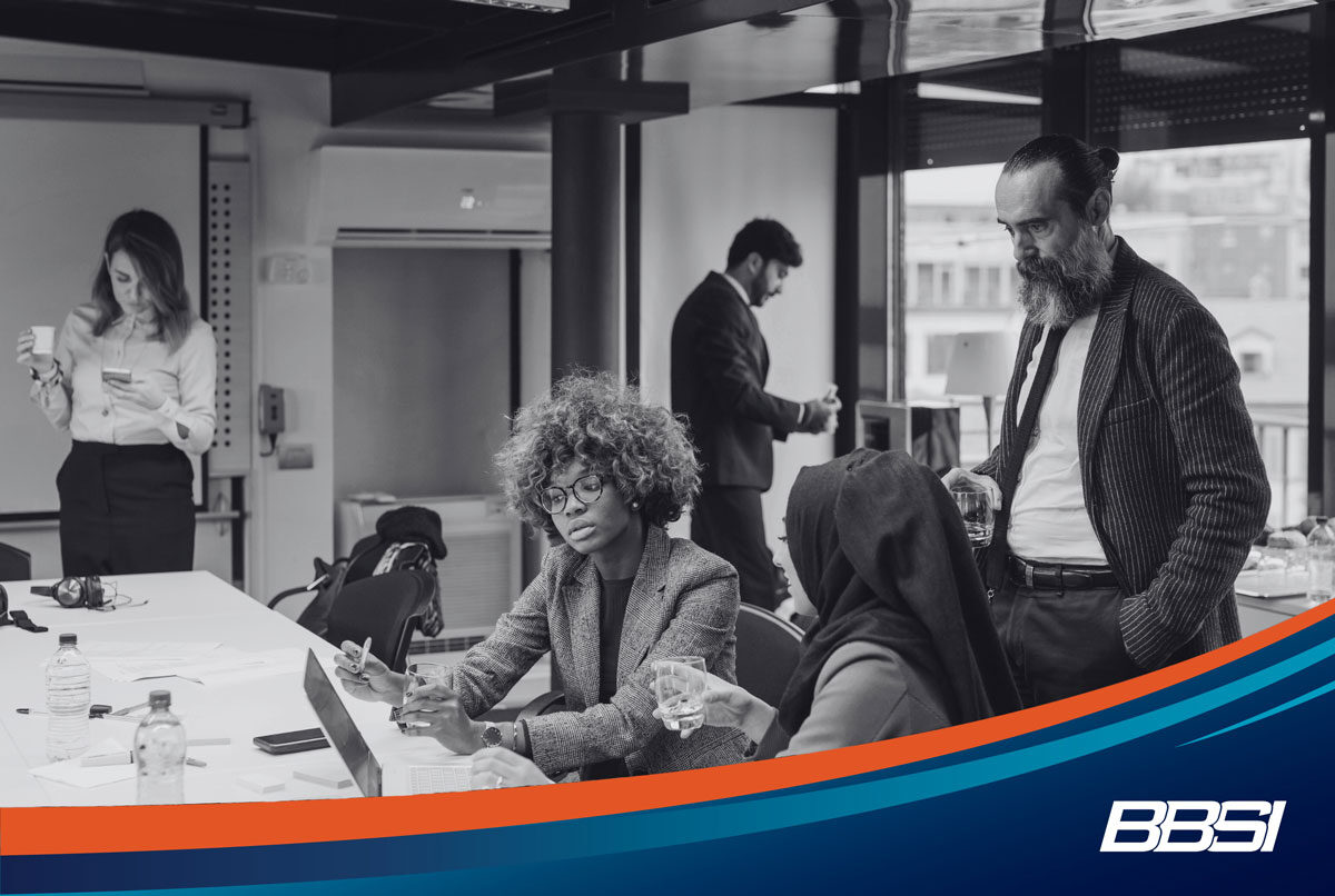 Two professionals sitting at a table discussing a new payroll provider service