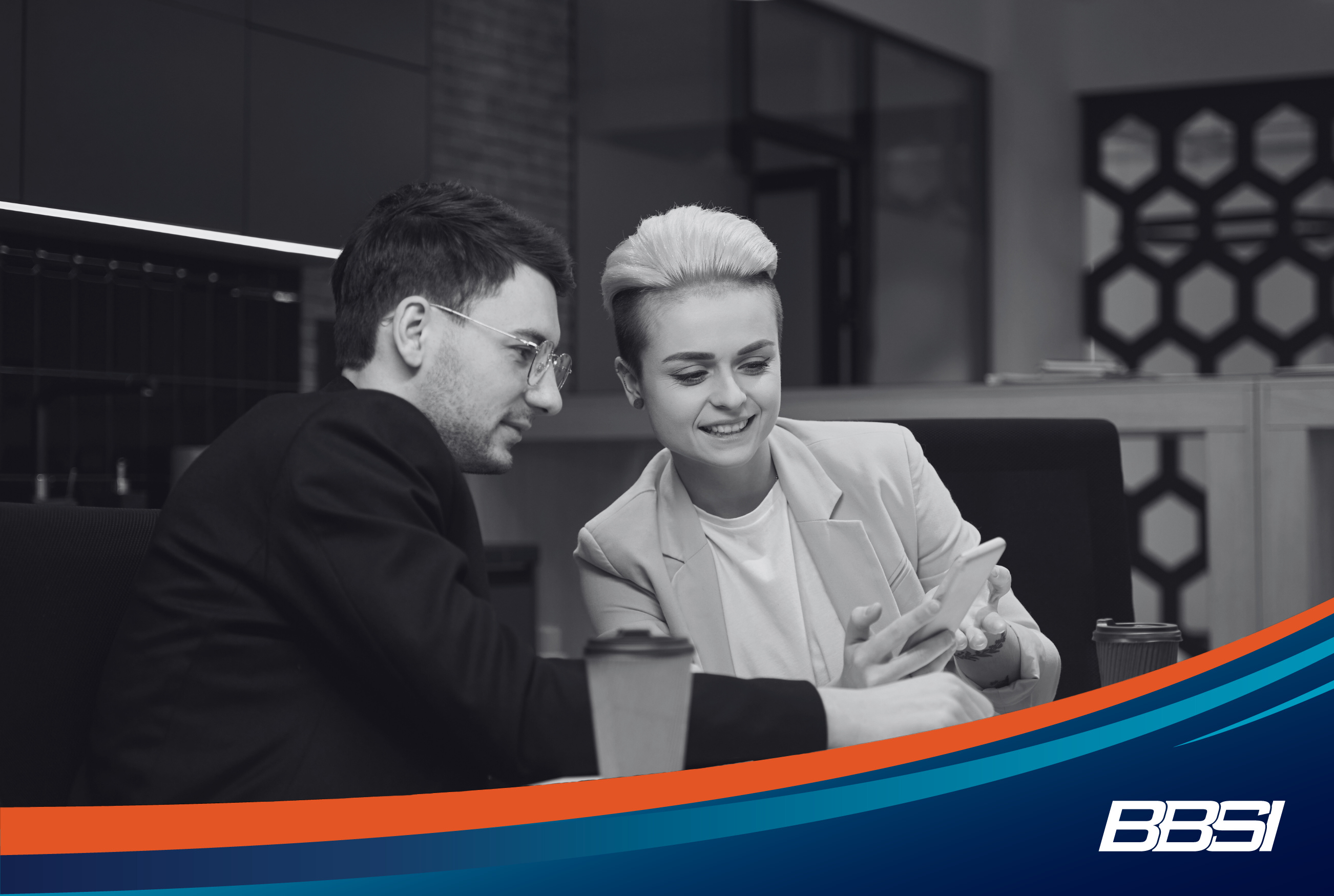 Two professionals sit together at a table discussing information on year-end tax planning