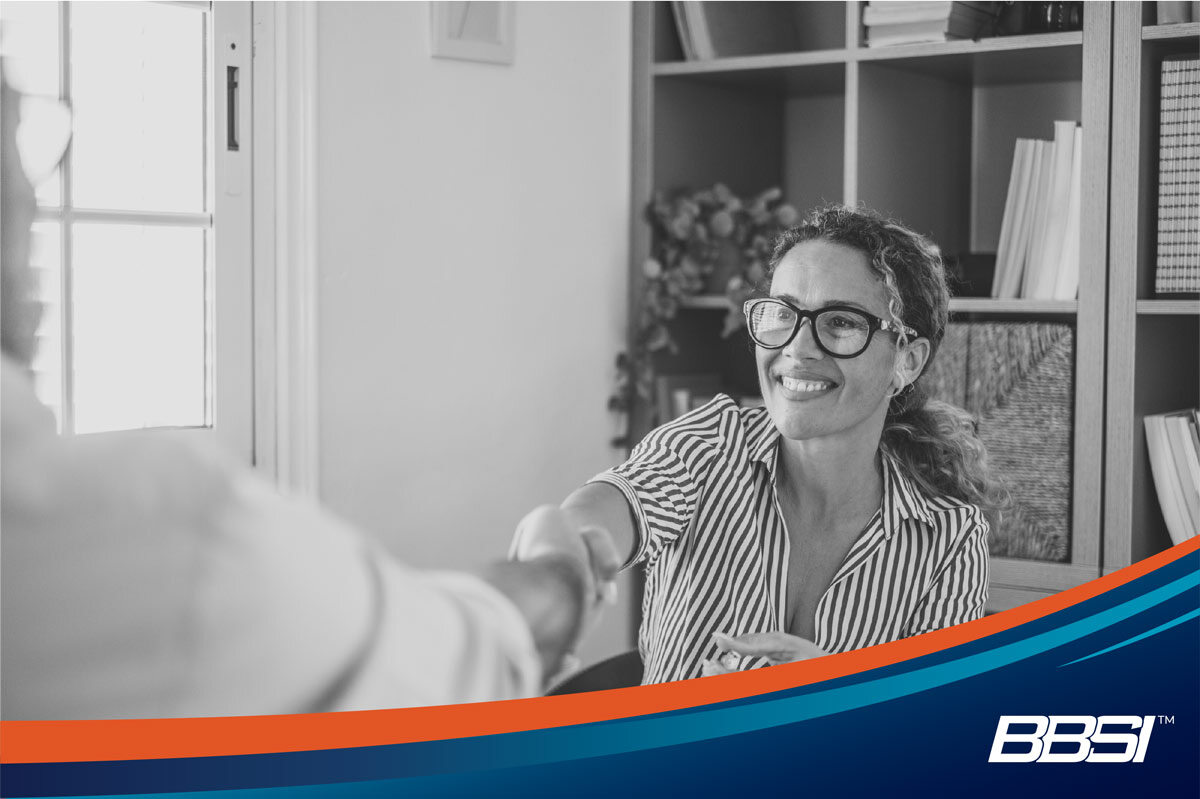 Businesswoman congratulates new hire after using her applicant tracking system