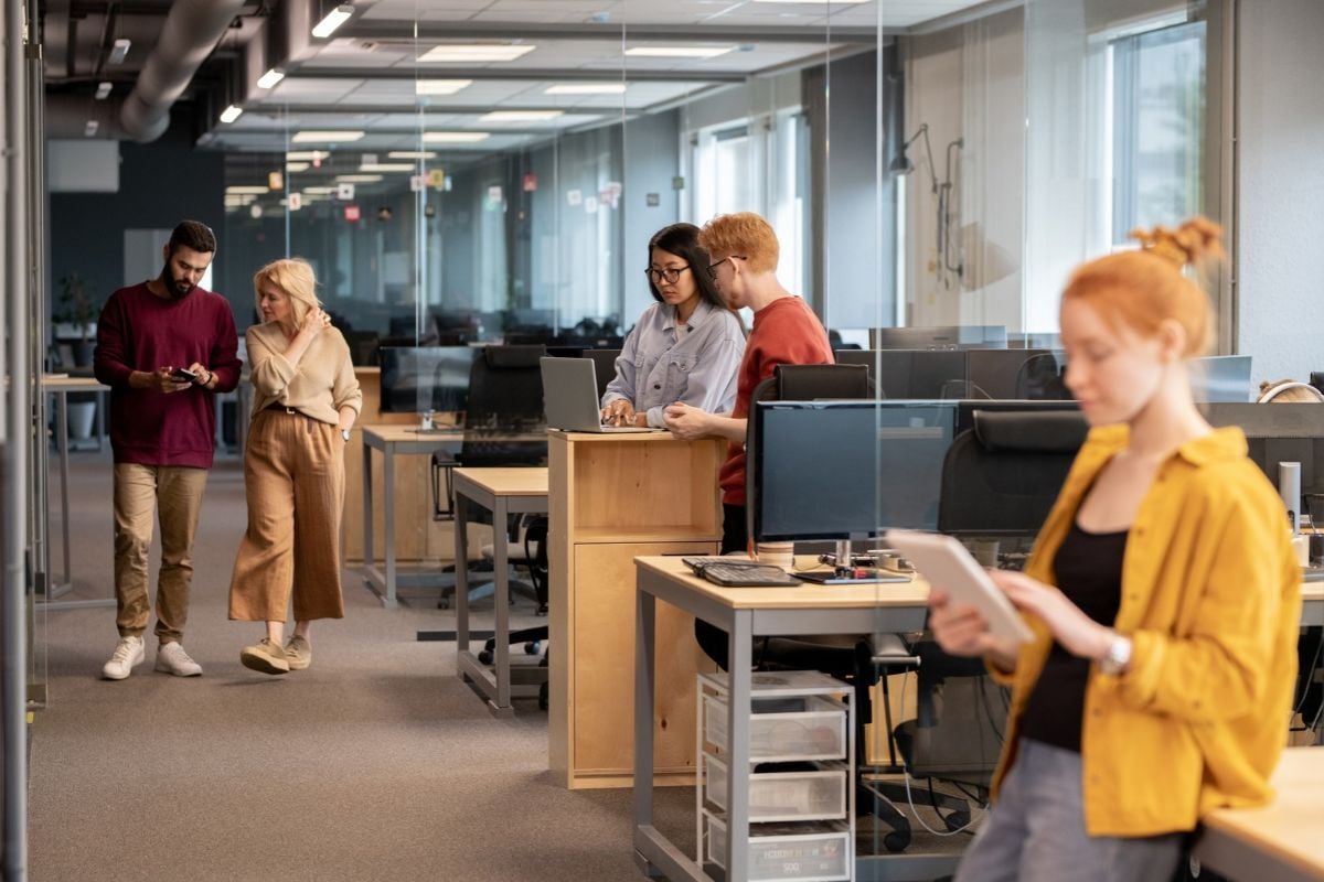 Coworkers working in an open office using attendance tracking software