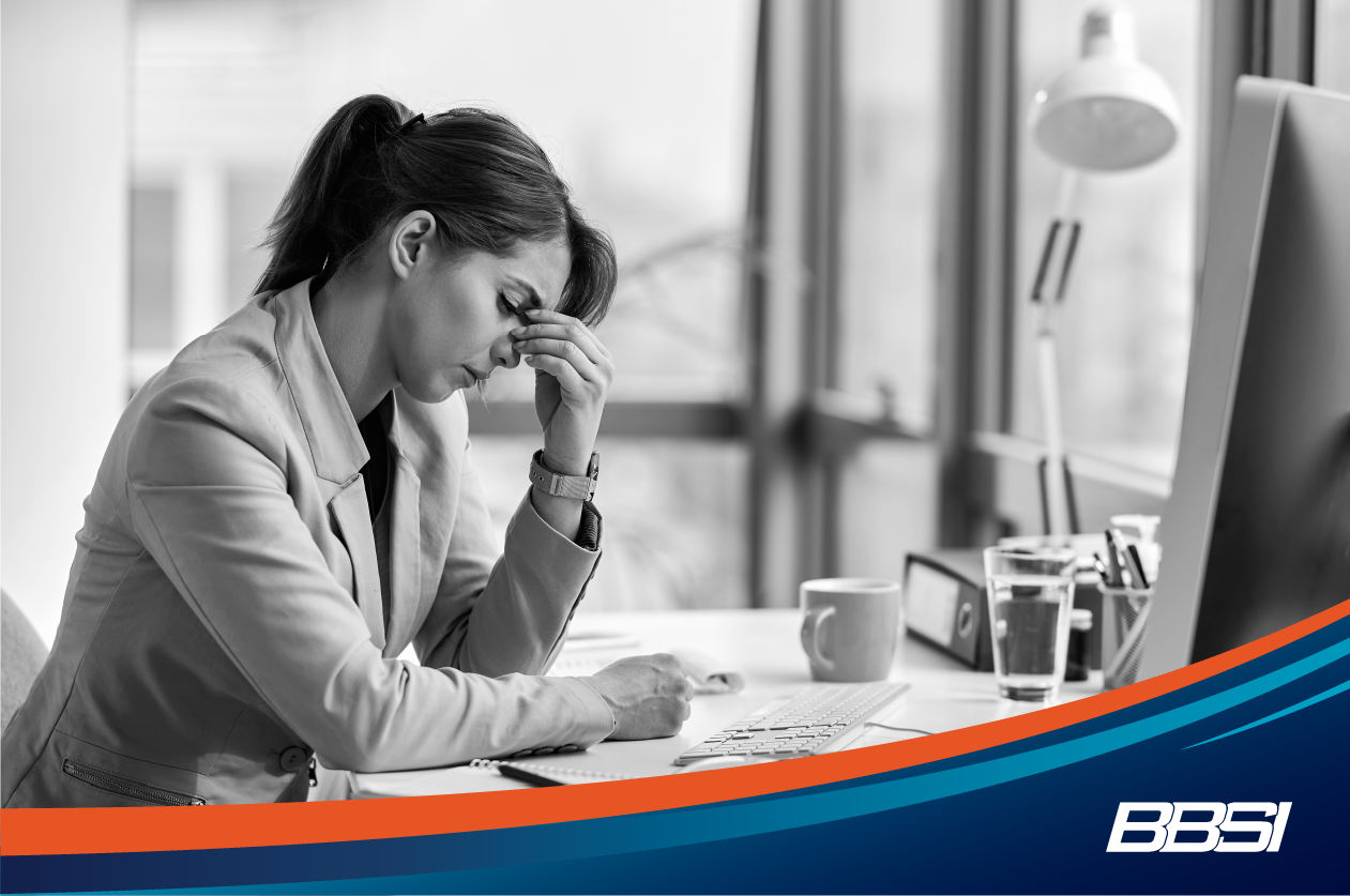 Woman sitting at her desk worrying about who she will let go