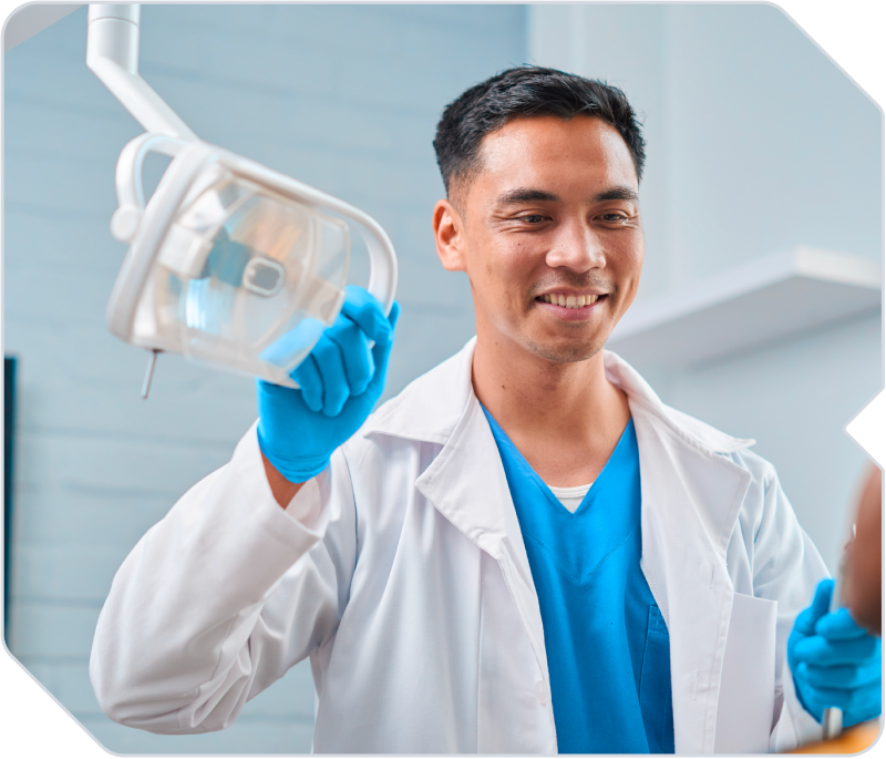 A doctor smiling at his patient in an exam room.