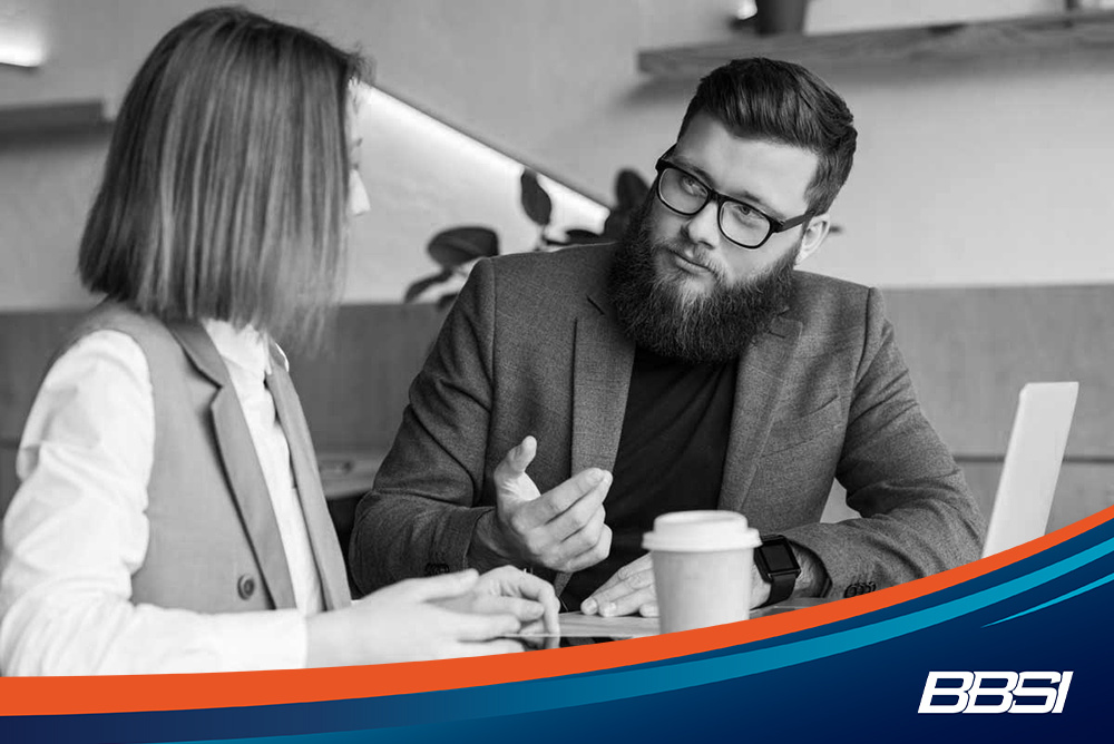 two young professionals discussing employee benefits packages