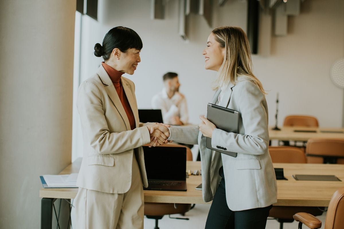 business professionals shake hands in a modern off learning co employment