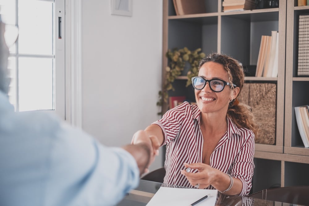 Business owner shaking hands with an insurance broker after signing up for a PEO